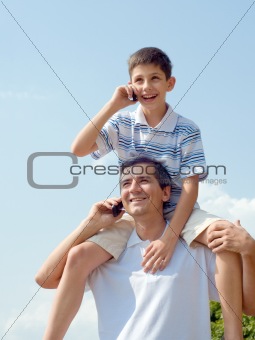 father and his son are speaking over mobiles