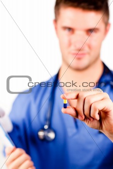 Young doctor holding a pill