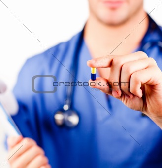 Young doctor holding a pill