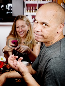Bored man with woman on cell phone
