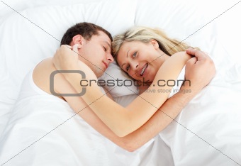 Woman lying in bed with a boy smiling at the camera