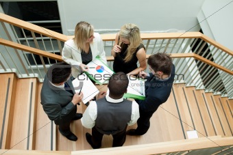 High view of business team having a meeting on stairs