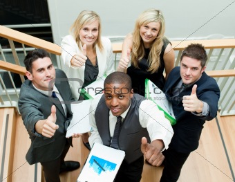 Business team having a meeting on stairs with thumbs up