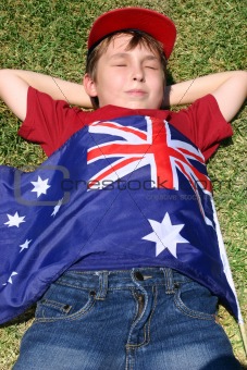 Patriotic boy with flag draped over him
