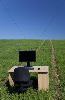 Desk and Computer In Green Field With Path