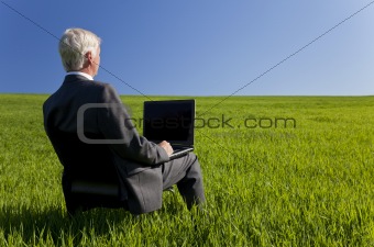 Blue Sky Thinking Businessman Using Laptop Computer in Green Fie