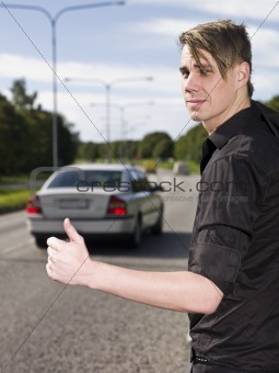 A young man hitchiking on the road