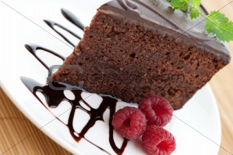 Slice of delicious chocolate cake with fresh raspberries