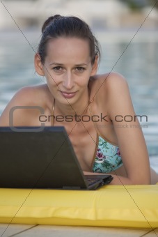 woman with laptop in pool