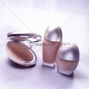 Three cosmetic objects on metallic background