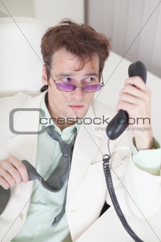 Businessman emotionally speaks on phone at office