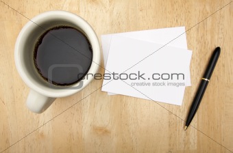 Blank Note Card, Pen and Coffee Cup on Wood Background.