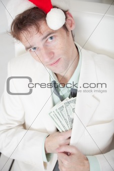 Businessman in white suit and Christmas cap hides money in pocke
