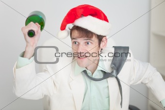 Young guy in christmas hat brawls with bottle in hand