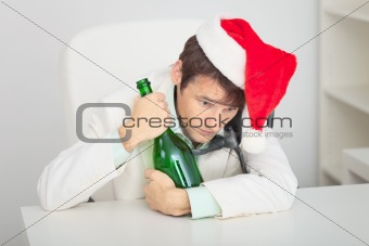 Young guy in Christmas cap with a bottle
