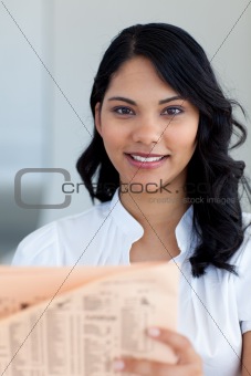 Beautiful businesswoman reading a newspaper