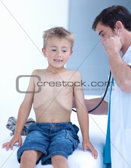 Doctor examinating a little boy with stethoscope