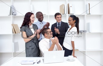Business team applauding a collegue in office