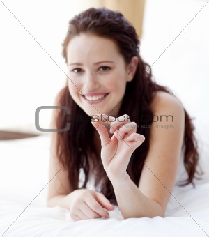 Woman in bed holding a pill