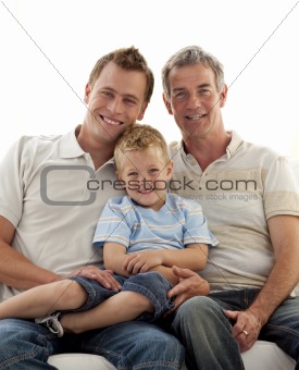 Smiling son, father and grandfather sitting on sofa