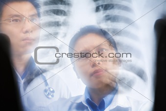 Two Asian doctor examining xray result