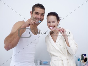 Couple cleaning their teeth in bathroom
