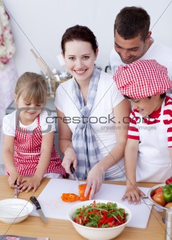 Happy family preparing a salad in kitchen