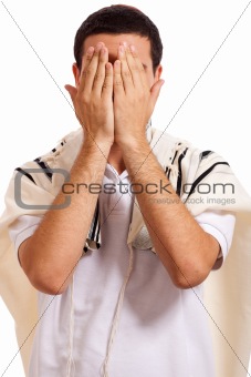 jewish man closing face with his hands while praying