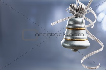 SIlver Christmas bell over blue background