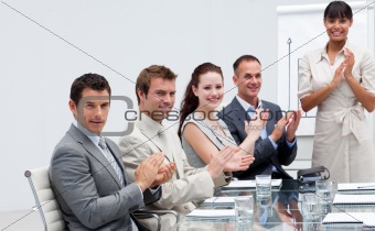 Business people applauding a colleague after reporting to sales 
