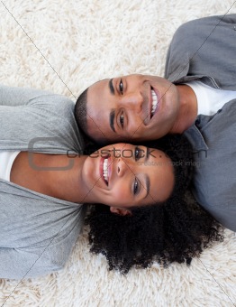 Smiling Afro-American couple lying on the floor