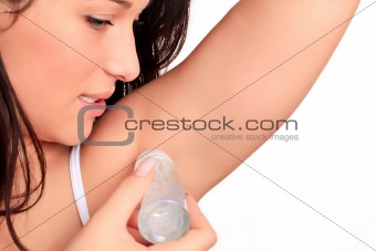 Woman applying deodorant in stick on to her armpits