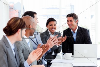 Happy business people clapping in a meeting