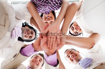 Smiling business people holding hands together in a circle 