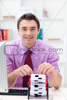 Smiling businessman consulting his business card holder 