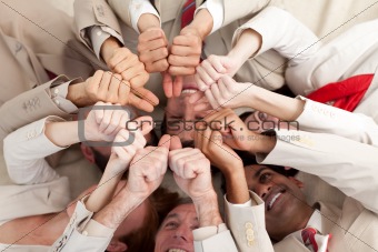 Successful business team with thumbs up lying in a circle
