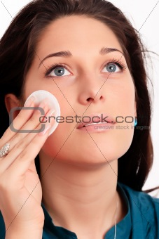 Young woman removing makeup