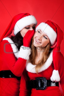 Two happy young Santa girl talking