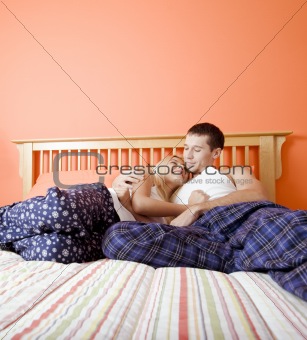 Young Couple in Pajamas Sitting on Bed