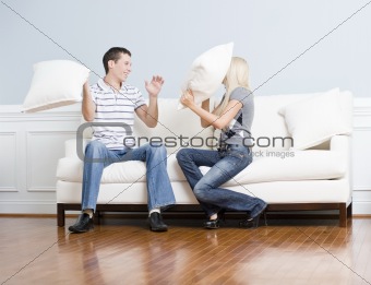 Young Couple Having a Pillow Fight on Sofa