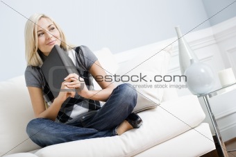 Smiling Woman Sitting on Couch and Holding a Book