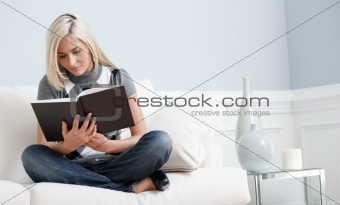 Woman Sitting on Couch and Reading a Book