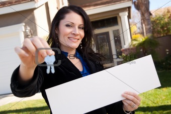 Happy Attractive Hispanic Woman Holding Blank Sign and Keys in Front of House.