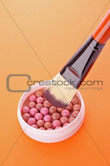 cosmetic brush and rouge  on the orange background