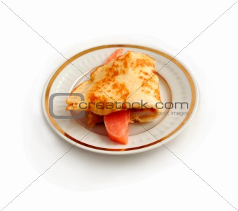 Salmon with  pancake on plate.