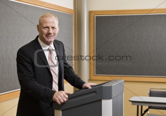 Business Man Standing at Podium Smiling