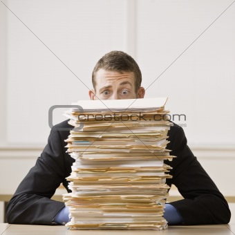 Businessman Behind Stack of File Folders