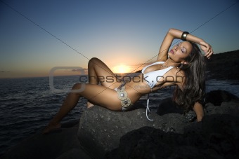 Woman Reclining in Swimsuit on Beach at Sunset