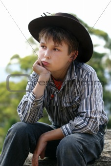 Country cowboy sitting on a rock