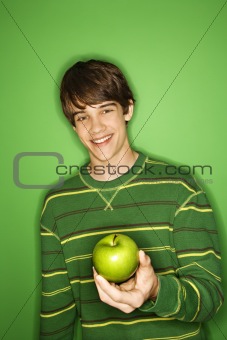 Caucasian teen boy holding apple.